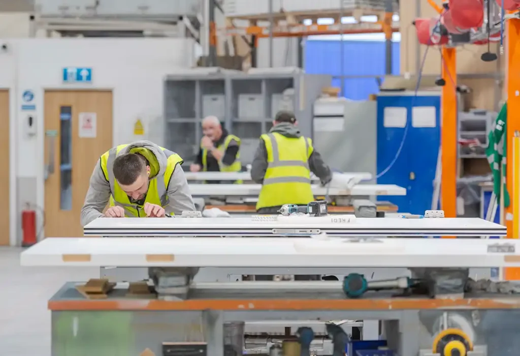 manufacturing staff in factory finalising decorative elements on fire doors